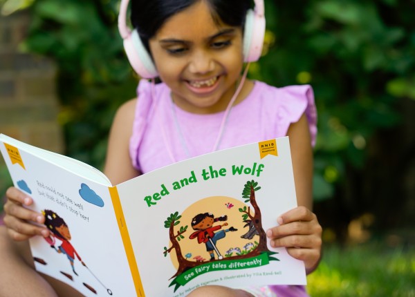 Girl reading and listening along to a children's book.