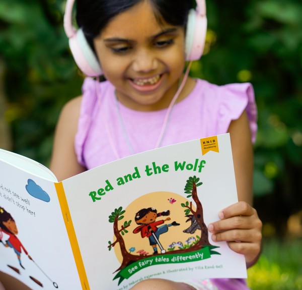 Girl reading and listening along to a children's book.